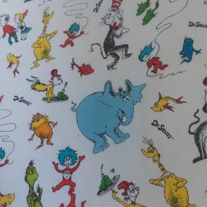 May include: A white background with a colorful pattern of Dr. Seuss characters. The characters include the Cat in the Hat, Thing 1 and Thing 2, the Lorax, and the Grinch. The background is white with a light blue, green, and red pattern.