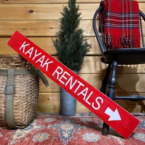 Kayak rentals shown in bright red for a pop of color to cabin, lake house or rustic lodge decor.