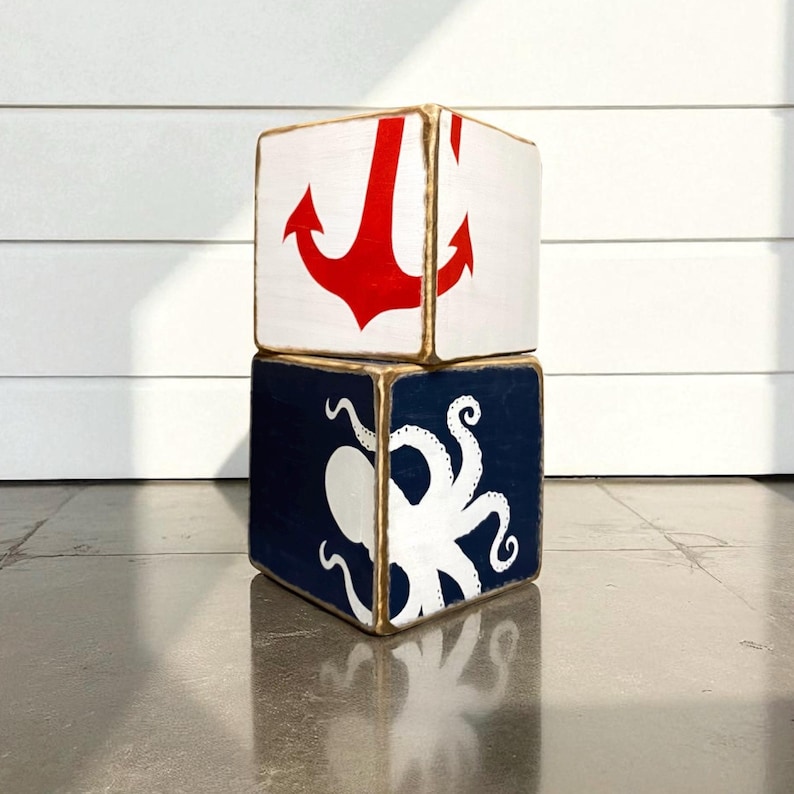Couple of  Coastal Anchor Tissue Box Covers arranged on a shelf in a coastal vacation rental, featuring hand-painted nautical anchor design for beach cottages, seaside vacation homes, coastal décor, or short-term rental interiors, perfect for coordinated bedrooms, bathrooms