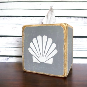 Coastal Shell Tissue Box Cover, Hand-Painted Wood, Beach House and Ocean-Inspired Decor for coastal cottages, beach houses, lake homes, or vacation rentals. Lightly distressed for a weathered, seaside look, perfect for bathrooms, living rooms, or as a thoughtful gift for ocean lovers and beach-themed décor enthusiasts. Handmade in Maine, adding timeless nautical charm and coastal style to any room.