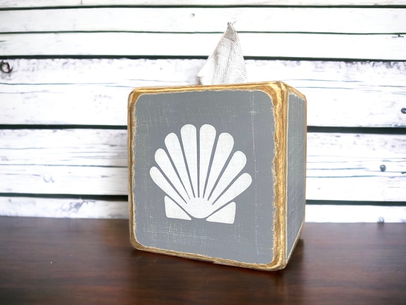 Coastal Shell Tissue Box Cover, Hand-Painted Wood, Beach House and Ocean-Inspired Decor for coastal cottages, beach houses, lake homes, or vacation rentals. Lightly distressed for a weathered, seaside look, perfect for bathrooms, living rooms, or as a thoughtful gift for ocean lovers and beach-themed décor enthusiasts. Handmade in Maine, adding timeless nautical charm and coastal style to any room.