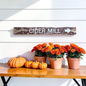 Handcrafted Cider Mill wood sign displayed in a cozy farmhouse kitchen, featuring a rustic distressed finish inspired by vintage apple orchards, fall harvest traditions, country farms, and autumn farmhouse decor