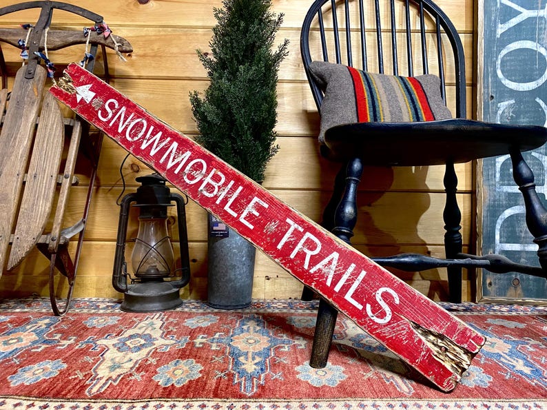Snowmobile trails directional wall sign with a distressed wood finish, crafted for cozy cabins, winter lodges, and northern trail lovers, made in Maine