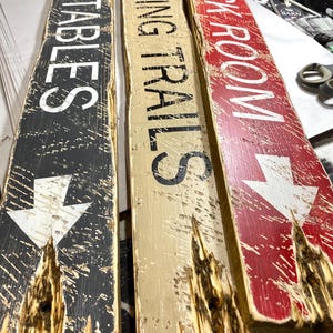 Tack Room Equestrian Sign Set displayed flat on a table, showing all three hand-distressed wood signs together. Perfect for Western barn, ranch, or rustic cabin décor, ideal for tack rooms, stables, vacation rentals, and lodge-style interiors. Highlights authentic hand-painted lettering, rustic wood textures, and Western character
