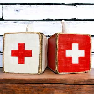 Rustic lifeguard-inspired beach house tissue box cover, perfect for lodge bathrooms, guest rooms, cabins, and poolside spaces. Vintage Swiss Cross first aid design adds nostalgic charm, while the handcrafted wood construction brings functional rustic warmth to any home