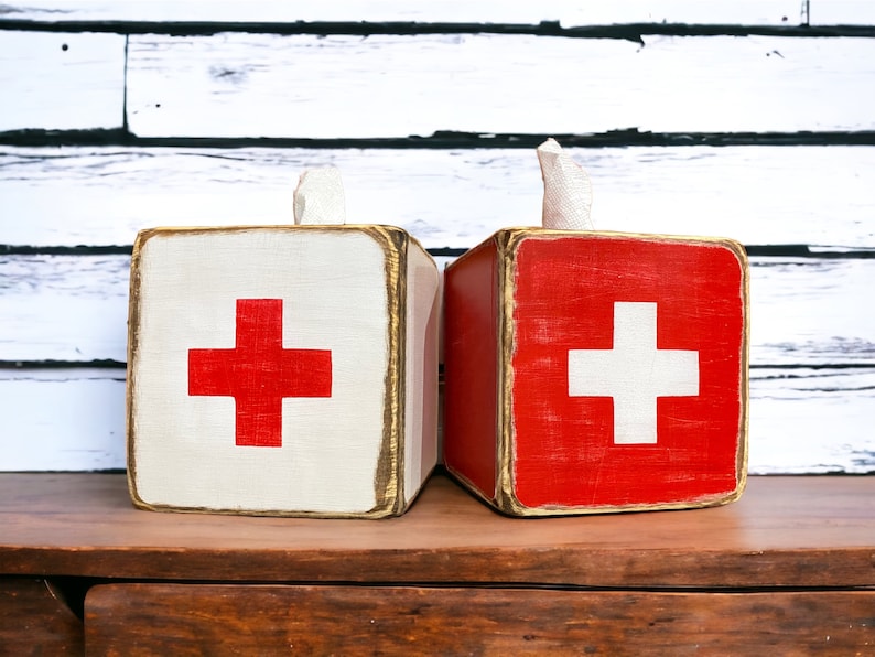 Rustic lifeguard-inspired beach house tissue box cover, perfect for lodge bathrooms, guest rooms, cabins, and poolside spaces. Vintage Swiss Cross first aid design adds nostalgic charm, while the handcrafted wood construction brings functional rustic warmth to any home