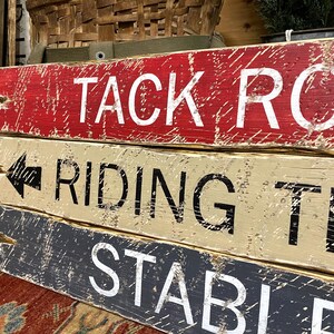 Close-up of the hand-painted lettering and textured wood grain on the Tack Room Sign Set, showcasing rustic Western charm, horse riding and barn décor, and cabin-inspired style. Ideal for Western cabins, lodges, man caves, vacation rentals, and tack rooms