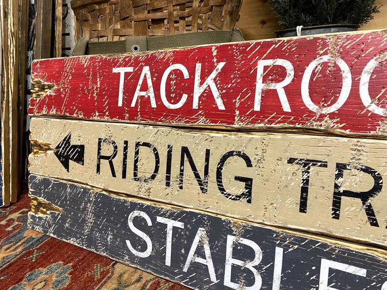 Close-up of the hand-painted lettering and textured wood grain on the Tack Room Sign Set, showcasing rustic Western charm, horse riding and barn décor, and cabin-inspired style. Ideal for Western cabins, lodges, man caves, vacation rentals, and tack rooms