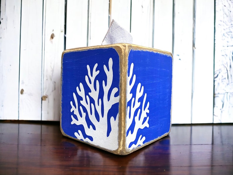 Coastal Coral Tissue Box Cover, Hand-Painted Wood, Beach House and Ocean-inspired for coastal cottages, beach houses, lake homes, or vacation rentals. Lightly distressed for a weathered, nautical look, perfect for bathrooms, living rooms, or as a thoughtful gift for ocean lovers. Handmade in Maine, adding timeless coastal charm and seaside style to any room.
