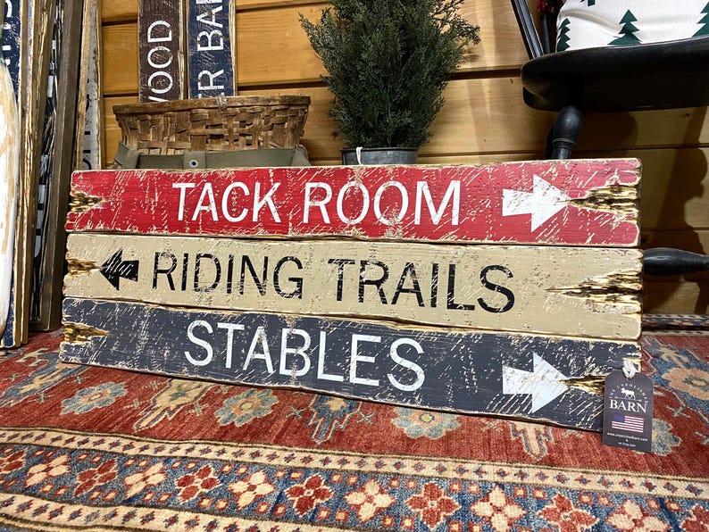 Tack Room Equestrian Sign Set displayed in a Western rustic cabin, showing hand-distressed wood signs styled above a tack room or stable area. Perfect for horse lovers, equestrian enthusiasts, vacation rentals, ranch homes, and cabin décor, highlighting authentic handcrafted style, Western character, and rustic charm