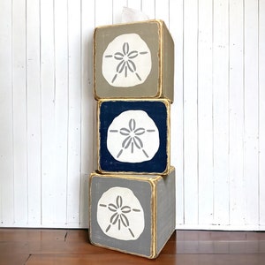 Sand dollar tissue box covers stacked together, coastal beach house decor with ocean-inspired sand dollar design, rustic distressed wood boxes styled for beach cottages, seaside bathrooms, lake houses, and vacation rentals, highlighting handcrafted quality and coastal charm, handmade in Maine