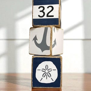 Multiple Coastal Anchor Tissue Box Covers grouped together on a coastal shelf, showing consistent hand-painted nautical anchor designs for beach cottages, vacation homes, seaside cabins, or short-term rentals, perfect for coordinated bedrooms, bathrooms, or living spaces