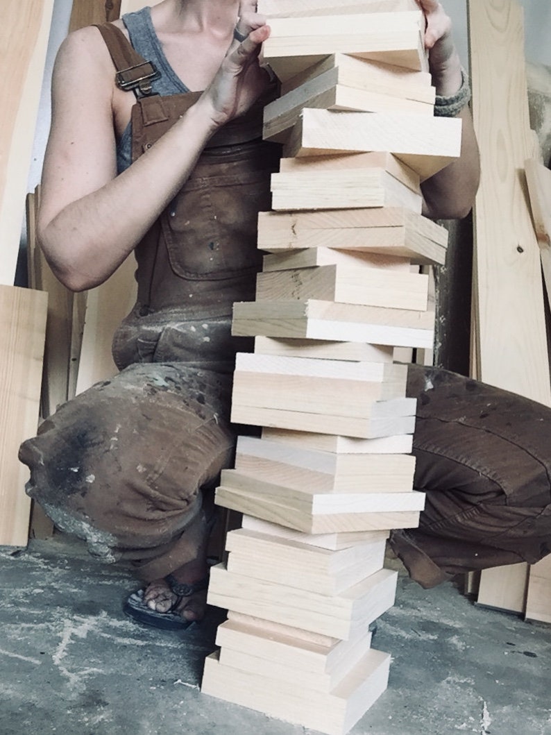 Artist holding unfinished wood while crafting coastal tissue box covers, behind-the-scenes woodworking process showing quality craftsmanship, raw materials, and handmade construction for rustic coastal, cabin, and lake house decor