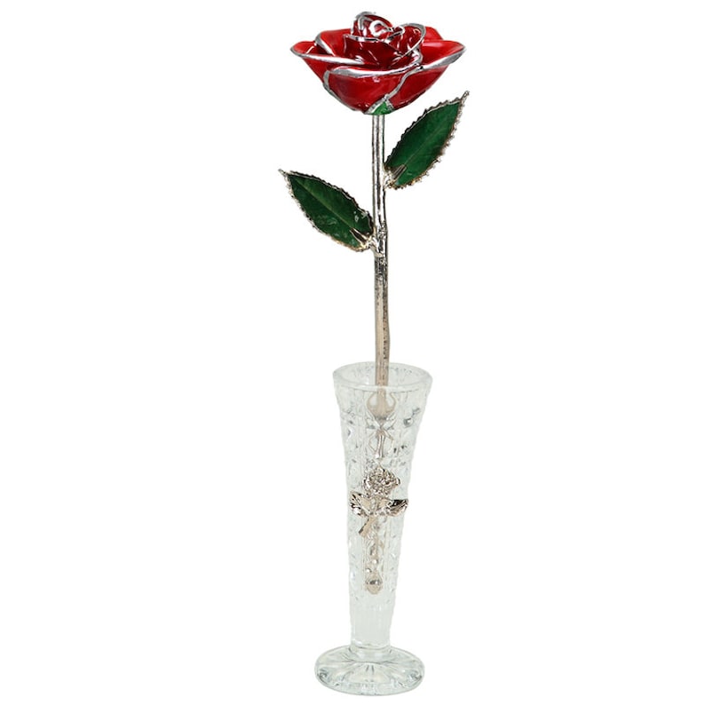May include: A single red rose with silver-plated leaves and stem, displayed in a clear glass vase with a cut-glass design.