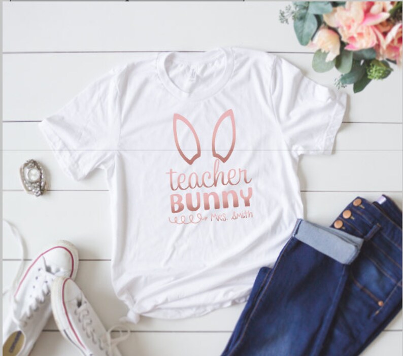 May include: White t-shirt with a rose gold bunny ear design and the text "teacher bunny" and "Mrs. Smith".
