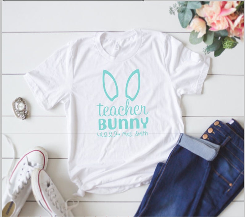 May include: White t-shirt with a turquoise bunny ear design and the text "teacher bunny" and "Mrs. Smith".