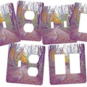 May include: Set of five decorative wall plate covers featuring a photograph of a path through an autumn forest with fallen leaves. The plates are designed to fit standard electrical outlets and light switches.