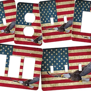 May include: Set of five light switch and outlet covers featuring a distressed American flag design with a bald eagle flying over the flag.
