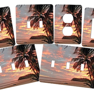May include: Set of six decorative wall plates featuring a tropical sunset scene with palm trees on a beach. The plates are designed to fit over standard light switches and electrical outlets.