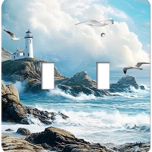 May include: A decorative light switch cover featuring a coastal scene. The artwork depicts a white lighthouse on a rocky cliff, with crashing waves and seagulls in flight. The sky is blue with fluffy white clouds.
