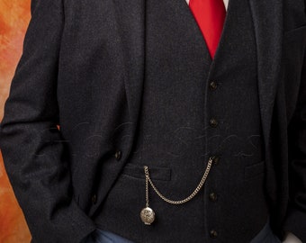May include: A dark gray suit jacket with a vest and a red tie. A pocket watch hangs from a chain attached to the vest.