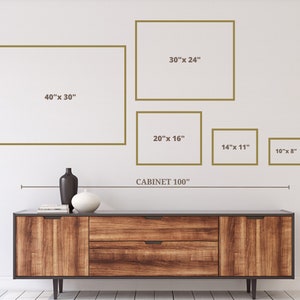 May include: A wooden cabinet with a dark finish, featuring two drawers and doors. Above the cabinet, five framed rectangles of varying sizes are displayed on a white wall. The largest frame is 40" x 30", and the smallest is 10" x 8". The text "CABINET 100" is also present.