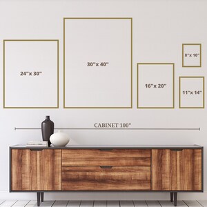 May include: A wooden cabinet with a dark finish, holding decorative vases and books. Above the cabinet are framed art pieces in various sizes, including 24" x 30", 30" x 40", 16" x 20", 11" x 14", and 8" x 10". The word "CABINET 100" is also visible.