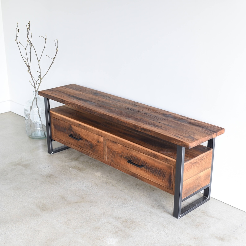 May include: A rustic wooden TV stand with two drawers and a shelf. The stand has a dark brown finish and black metal legs.