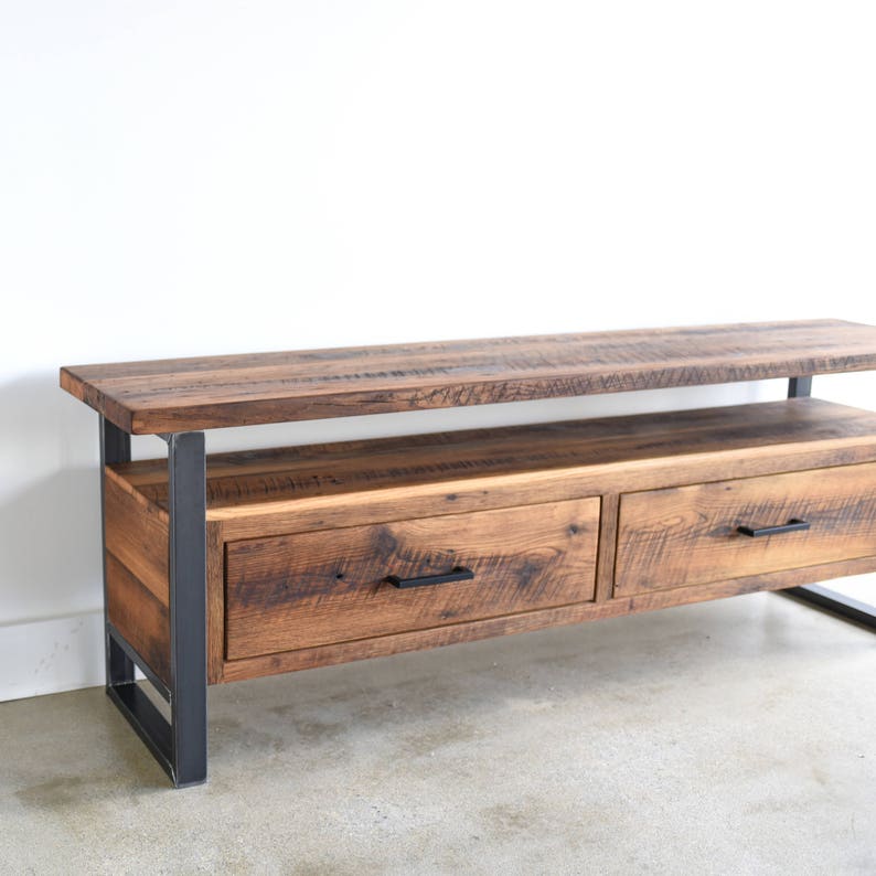 May include: A rustic wooden media console with two drawers and a shelf. The console has a dark brown wood finish and black metal legs.