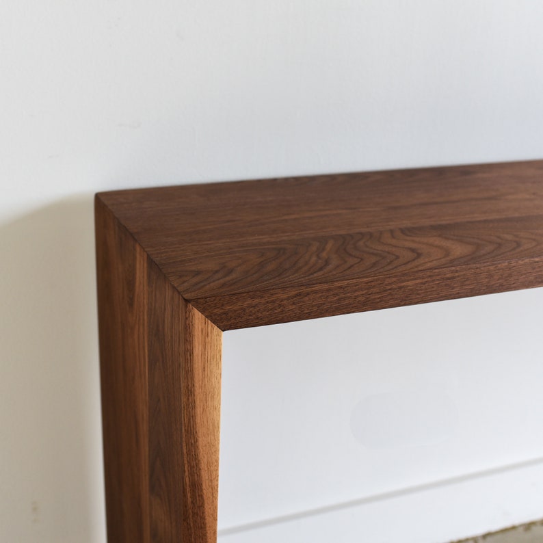May include: A dark brown wooden console table with a rectangular top and a simple, modern design.
