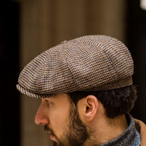 May include: A brown and tan tweed newsboy cap with a checkered pattern.