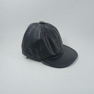 May include: A black leather baseball cap with a curved brim.