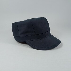 May include: A dark blue, cotton, military style cap with a flat brim.