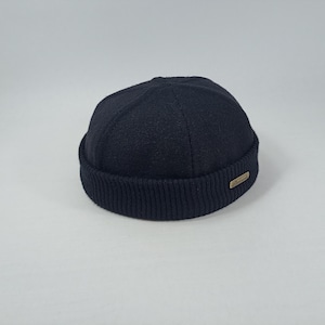 May include: A black wool beanie with a ribbed cuff and a small brown label.