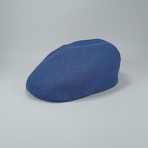 Peut inclure: Casquette plate bleue en tissu texturé. La casquette est de couleur unie et de forme arrondie classique. Le chapeau est probablement fait d'une matière respirante, adaptée aux températures plus chaudes.