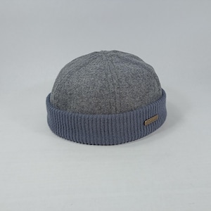 May include: A grey wool beanie with a blue ribbed knit brim. The beanie has a simple design and is perfect for cold weather.