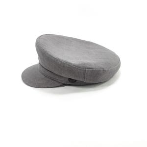 May include: A gray, flat-brimmed hat with a rounded crown and a small, curved visor. The hat has a textured appearance and a button detail on the side. This classic style hat is suitable for various occasions.