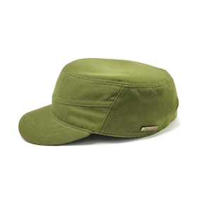 May include: Olive green military-style cap with a short brim. The cap has a structured crown and a small, rectangular metal accent on the side. The fabric appears to be a durable cotton or similar material.