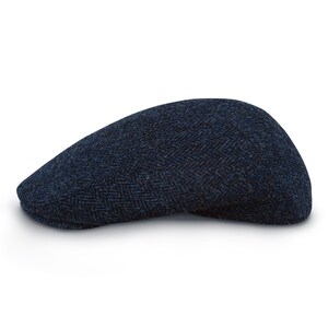 May include: A navy blue herringbone pattern flat cap. The cap is made of a textured fabric and has a classic, rounded shape. The cap is a stylish accessory for any outfit.