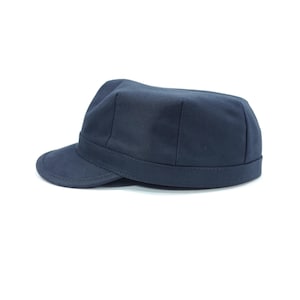 May include: A navy blue military-style cap with a short brim. The cap has a structured crown and a band around the base. The hat is made of a solid, dark blue fabric and is set against a white background.