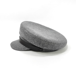 May include: A gray wool hat with a short brim and a black leather band. The hat has a rounded crown and a button detail on the side. This classic style hat is a great accessory.