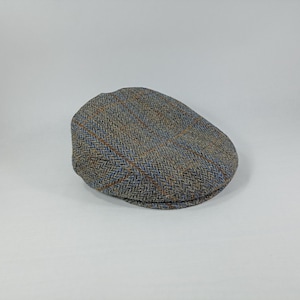 May include: A brown, blue, and orange tweed flat cap.