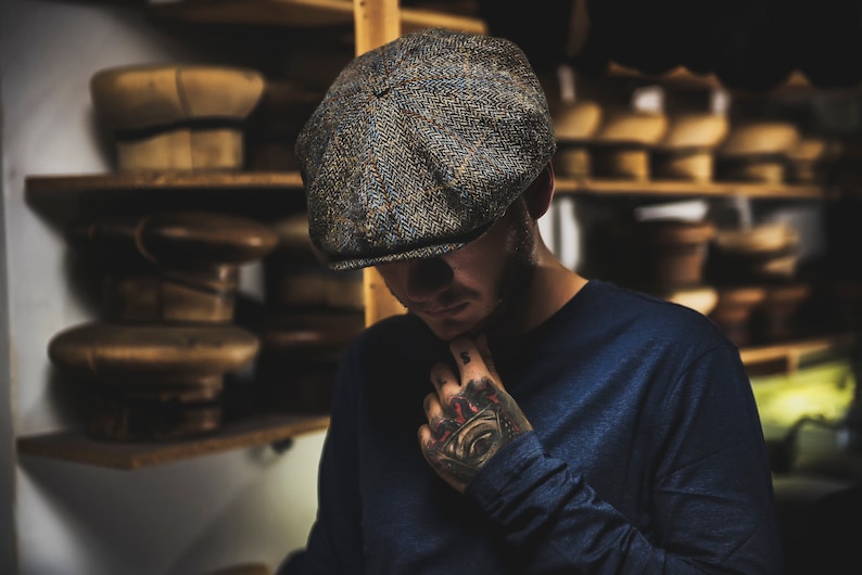 May include: A tweed newsboy cap with a dark blue, green, and brown pattern.
