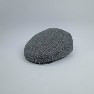 May include: A black and white patterned newsboy cap.