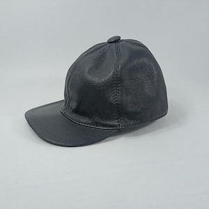 May include: A black leather baseball cap with a curved brim.