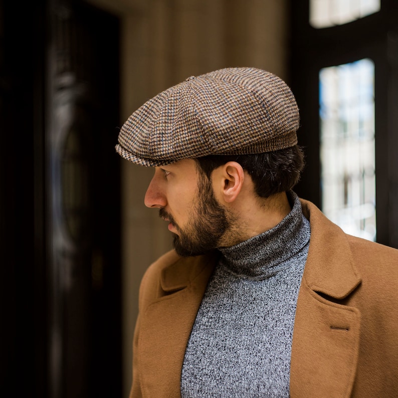 May include: A brown and tan tweed newsboy cap with a checkered pattern.
