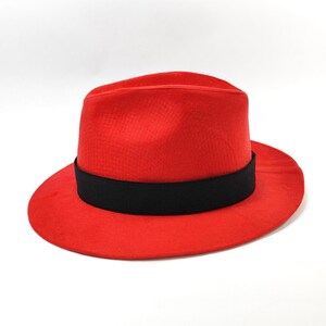 Może przedstawiać: Żywy czerwony kapelusz typu fedora z czarną opaską. Kapelusz ma klasyczny design ze strukturalną koroną i szerokim rondem. Ten stylowy kapelusz to świetny dodatek do każdego stroju.