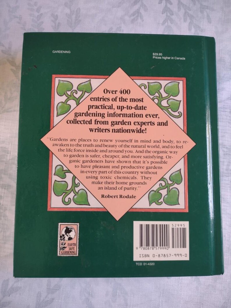 May include: A green book cover with a pink and green illustration of a garden. The book title is "Earth Safe Gardening" and the text on the cover reads "Over 400 entries of the most practical, up-to-date gardening information ever, collected from garden experts and writers nationwide!"