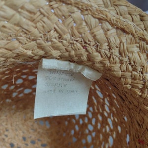 Puede incluir: Primer plano del interior de un sombrero de paja con una etiqueta blanca que dice "JN 42936 50% Straw 100% Italy Made in Italy".
