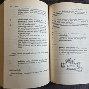 May include: Open book with text and illustrations about sewing. The left page has text about spools of thread and knitting needles. The right page has text about sewing pins and sleeves, with illustrations of sewing tools.